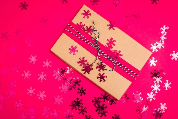 Christmas presents delivery service. craft gift box on red or pink background, top view. Xmas