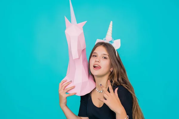 Kawaii tonårstjej. Söt ung kvinna med enhörning horn innehav handgjort papper rosa enhörning över blå bakgrund. — Stockfoto