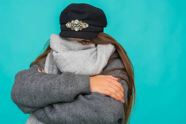 Headshot Portrait of happy teenage ginger girl wearing coat and wool cap. Blue background. Winter cold concept. — Stock Photo, Image