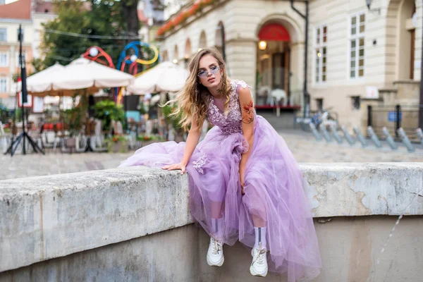 Portrait of young gil wearing dress and violet sunglasses. tattoes over her arms and face. Close up. City walk. Subculture attributes. — Stockfoto