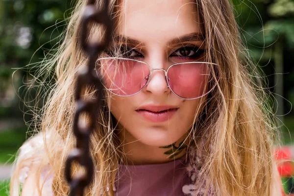 Portrait of young gil wearing dress and violet sunglasses. tattoes over her arms and face. Close up. City walk. Subculture attributes. — Stockfoto