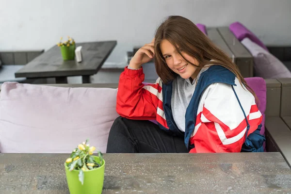 Retrato de joven atractiva linda adolescente mirando a la cámara sonriendo con el concepto de estilo de vida urbano en la cafetería al aire libre. Pega a un tonto . —  Fotos de Stock