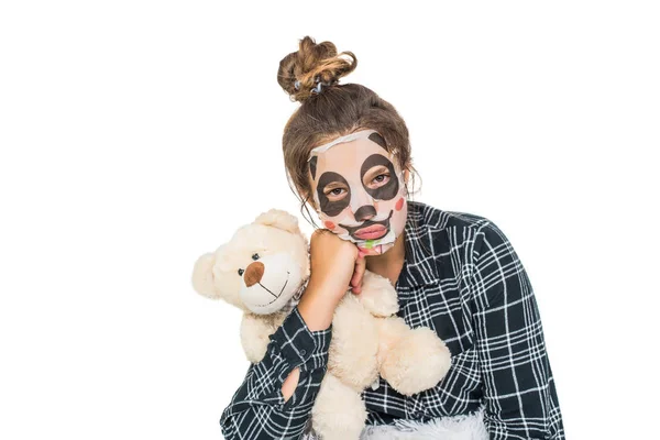 Joven adolescente con máscara de panda facial mirando a la cámara aislada sobre fondo blanco. Procedimiento cosmético. Spa de belleza y cosmetología . — Foto de Stock