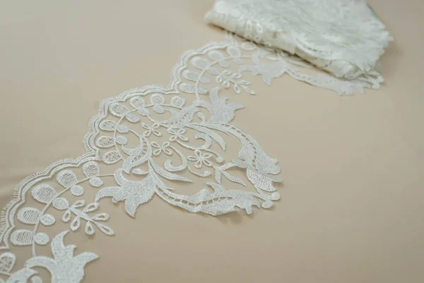 Texture lace fabric. lace on white background studio. thin fabric made of yarn or thread. a background image of ivory-colored lace cloth. White lace on beige background. — Stock Photo, Image