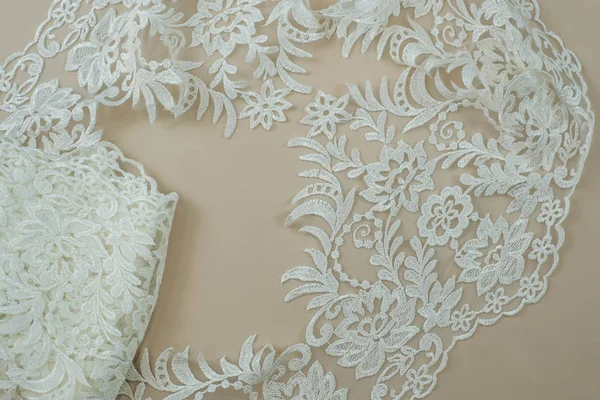 Texture lace fabric. lace on white background studio. thin fabric made of yarn or thread. a background image of ivory-colored lace cloth. White lace on beige background.