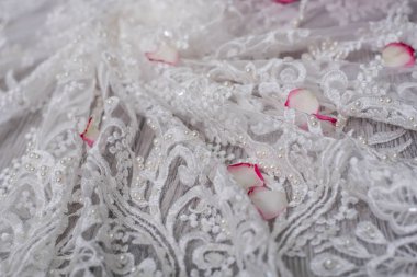 Beyaz ahşap arka plan, beyaz bahar çiçekleri güller ve dantel kurdeleler. Mutlu kadınlar günü. Tahta zemindeki dantelin dokusu.