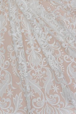Fildişi renkli dantel kumaşın arkaplan resmi. Bej arkaplanda beyaz dantel.
