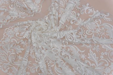 Fildişi renkli dantel kumaşın arkaplan resmi. Bej arkaplanda beyaz dantel.