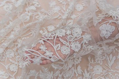 Fildişi renkli dantel kumaşın arkaplan resmi. Bej arkaplanda beyaz dantel.