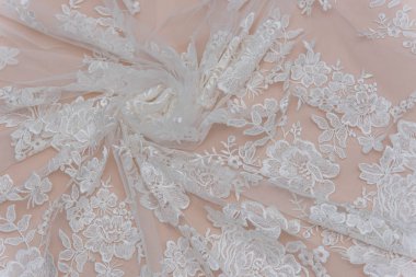 Fildişi renkli dantel kumaşın arkaplan resmi. Bej arkaplanda beyaz dantel.