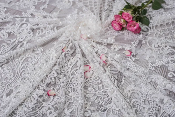 White wooden background with white spring flowers roses and lace ribbon. Happy womans day. The texture of lace on wooden background. — Stock Photo, Image