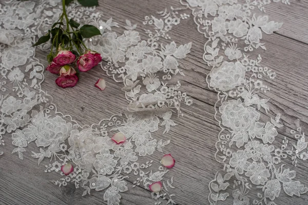 White wooden background with white spring flowers roses and lace ribbon. Happy womans day. The texture of lace on wooden background. — Stock Photo, Image