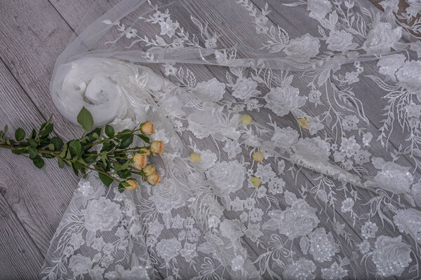 The texture of lace on wooden background decoreted roses.