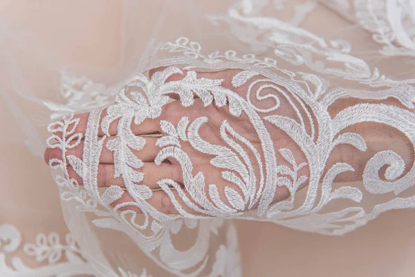 A background image of ivory-colored lace cloth. White lace on beige background. — Stock Photo, Image