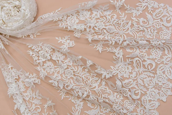 A background image of ivory-colored lace cloth. White lace on beige background. — Stock Photo, Image