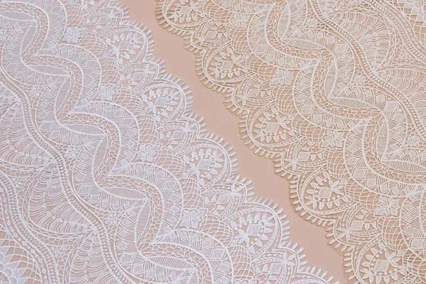 a background image of ivory-colored lace cloth. White lace on beige background.