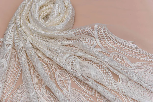 a background image of ivory-colored lace cloth. White lace on beige background.