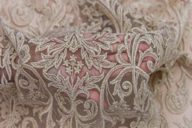 Doku danteli kumaş. Beyaz arka plan stüdyosunda dantel. İplik ya da iplikten yapılmış ince kumaş. Fildişi renkli dantel kumaşın arkaplan resmi. Bej arkaplanda bej rengi dantel.