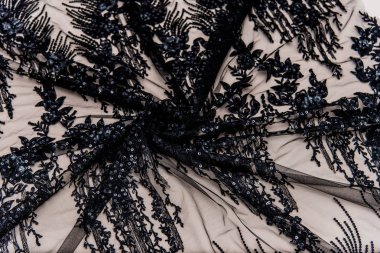 Doku danteli kumaş. Beyaz arka plan stüdyosunda dantel. İplik ya da iplikten yapılmış ince kumaş. Fildişi renkli dantel kumaşın arkaplan resmi. Bej arkaplanda siyah dantel.