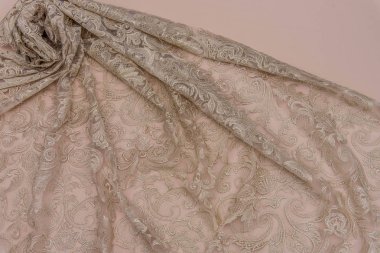 Doku danteli kumaş. Beyaz arka plan stüdyosunda dantel. İplik ya da iplikten yapılmış ince kumaş. Fildişi renkli dantel kumaşın arkaplan resmi. Bej arkaplanda bej rengi dantel.