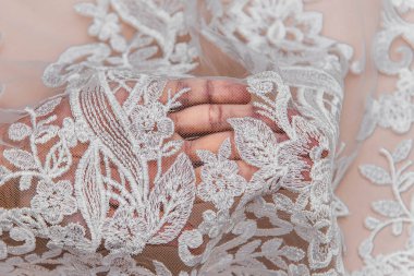 Doku danteli kumaş. Beyaz arka plan stüdyosunda dantel. İplik ya da iplikten yapılmış ince kumaş. Fildişi renkli dantel kumaşın arkaplan resmi. Bej arkaplanda beyaz dantel.