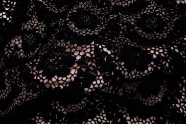 Doku danteli kumaş. Beyaz arka plan stüdyosunda dantel. İplik ya da iplikten yapılmış ince kumaş. Fildişi renkli dantel kumaşın arkaplan resmi. Bej arkaplanda siyah dantel.