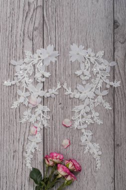 Beyaz ahşap arka plan, beyaz bahar çiçekleri güller ve dantel kurdeleler. Mutlu kadınlar günü. Tahta zemindeki dantelin dokusu.