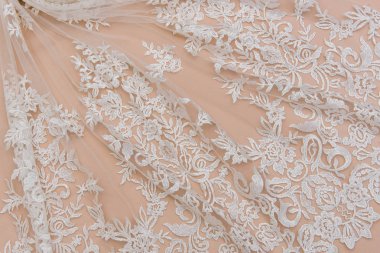 Fildişi renkli dantel kumaşın arkaplan resmi. Bej arkaplanda beyaz dantel.