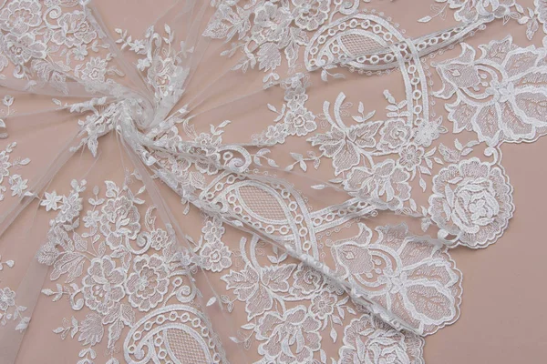 Texture lace fabric. lace on white background studio. thin fabric made of yarn or thread. a background image of ivory-colored lace cloth. White lace on beige background.