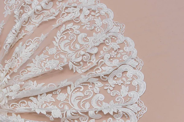 Texture lace fabric. lace on white background studio. thin fabric made of yarn or thread. a background image of ivory-colored lace cloth. White lace on beige background.