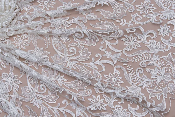 Texture lace fabric. lace on white background studio. thin fabric made of yarn or thread. a background image of ivory-colored lace cloth. White lace on beige background.