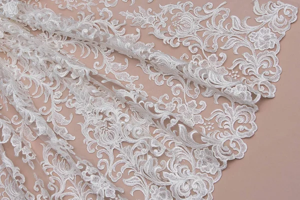 Texture lace fabric. lace on white background studio. thin fabric made of yarn or thread. a background image of ivory-colored lace cloth. White lace on beige background.