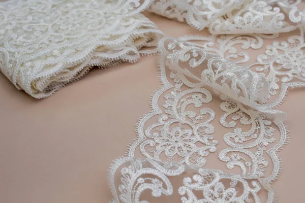 Texture lace fabric. lace on white background studio. thin fabric made of yarn or thread. a background image of ivory-colored lace cloth. White lace on beige background. — Stock Photo, Image