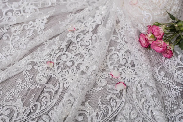 White wooden background with white spring flowers roses and lace ribbon. Happy womans day. The texture of lace on wooden background. — Stock Photo, Image