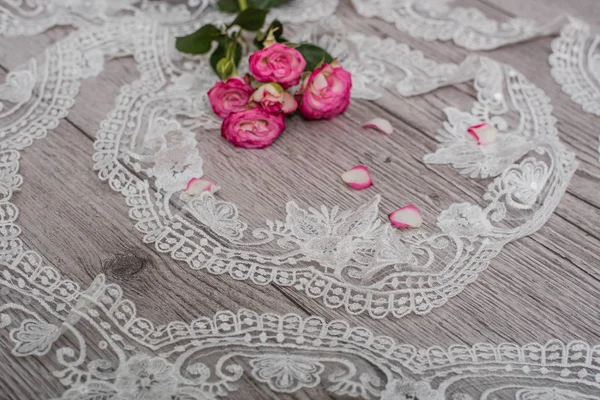 Fondo bianco in legno con fiori bianchi primaverili rose e nastro di pizzo. Felice giorno delle donne. La trama del pizzo su sfondo di legno. — Foto Stock