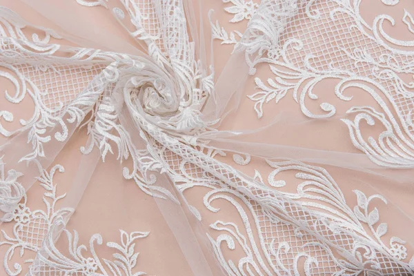 A background image of ivory-colored lace cloth. White lace on beige background. — Stock Photo, Image