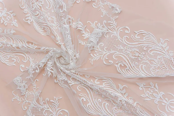 A background image of ivory-colored lace cloth. White lace on beige background. — Stock Photo, Image