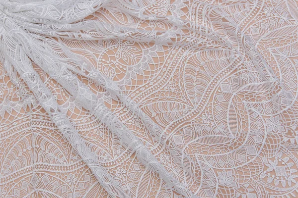 A background image of ivory-colored lace cloth. White lace on beige background. — Stock Photo, Image