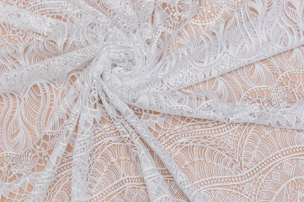 A background image of ivory-colored lace cloth. White lace on beige background. — Stock Photo, Image