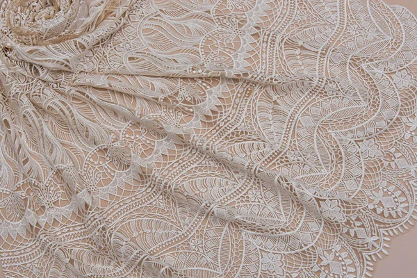 A background image of ivory-colored lace cloth. White lace on beige background. — Stock Photo, Image