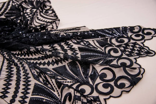 A background image of lace cloth. Black lace on beige background. — Stockfoto