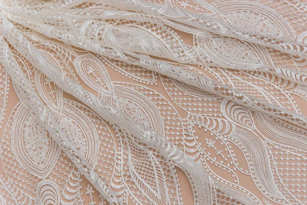 Une image de fond de tissu de dentelle de couleur ivoire. Dentelle blanche sur fond beige . — Photo