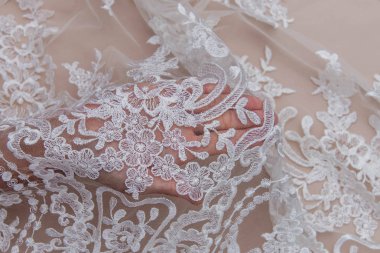 Doku danteli kumaş. Bej arka plan stüdyosunda dantel. İplik ya da iplikten yapılmış ince kumaş. Tipik olarak pamuk ya da ipekten yapılır. Döngü, bükme ya da örgü ipliği desenleri ile yapılır.