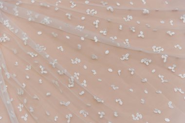 Doku danteli kumaş. Beyaz arka plan stüdyosunda dantel. İplik ya da iplikten yapılmış ince kumaş. Fildişi renkli dantel kumaşın arkaplan resmi. Bej arkaplanda beyaz dantel.