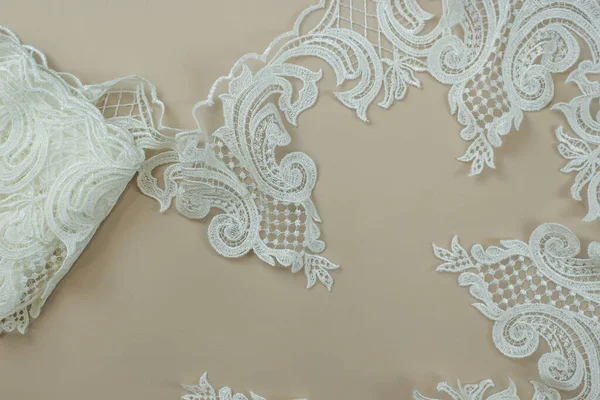 Texture lace fabric. lace on white background studio. thin fabric made of yarn or thread. a background image of ivory-colored lace cloth. White lace on beige background.