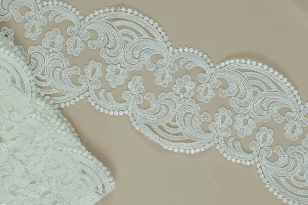 Texture lace fabric. lace on white background studio. thin fabric made of yarn or thread. a background image of ivory-colored lace cloth. White lace on beige background. — Stock Photo, Image