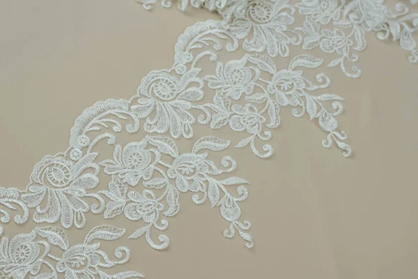 Texture lace fabric. lace on white background studio. thin fabric made of yarn or thread. a background image of ivory-colored lace cloth. White lace on beige background.