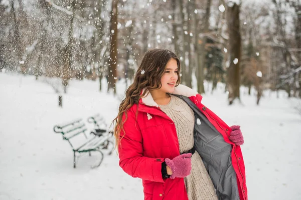 Jul, nyår, vintersemester koncept. Söt tonårstjej med lockigt hår. leka med snö i parken. — Stockfoto