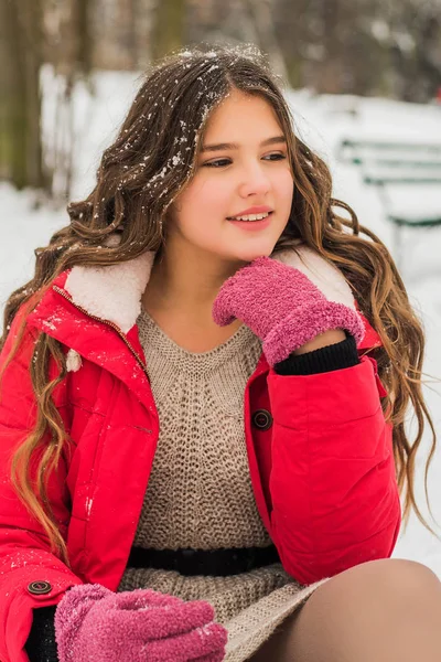 Noël, Nouvel An, vacances d'hiver concept. Adolescente mignonne aux cheveux bouclés. jouer avec la neige dans le parc. — Photo