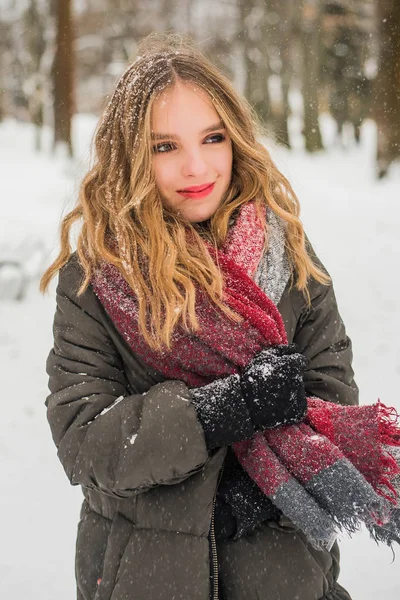 クリスマス、新年、冬の休暇の概念。巻き毛の可愛い10代の女の子。公園で雪と遊ぶのは. — ストック写真